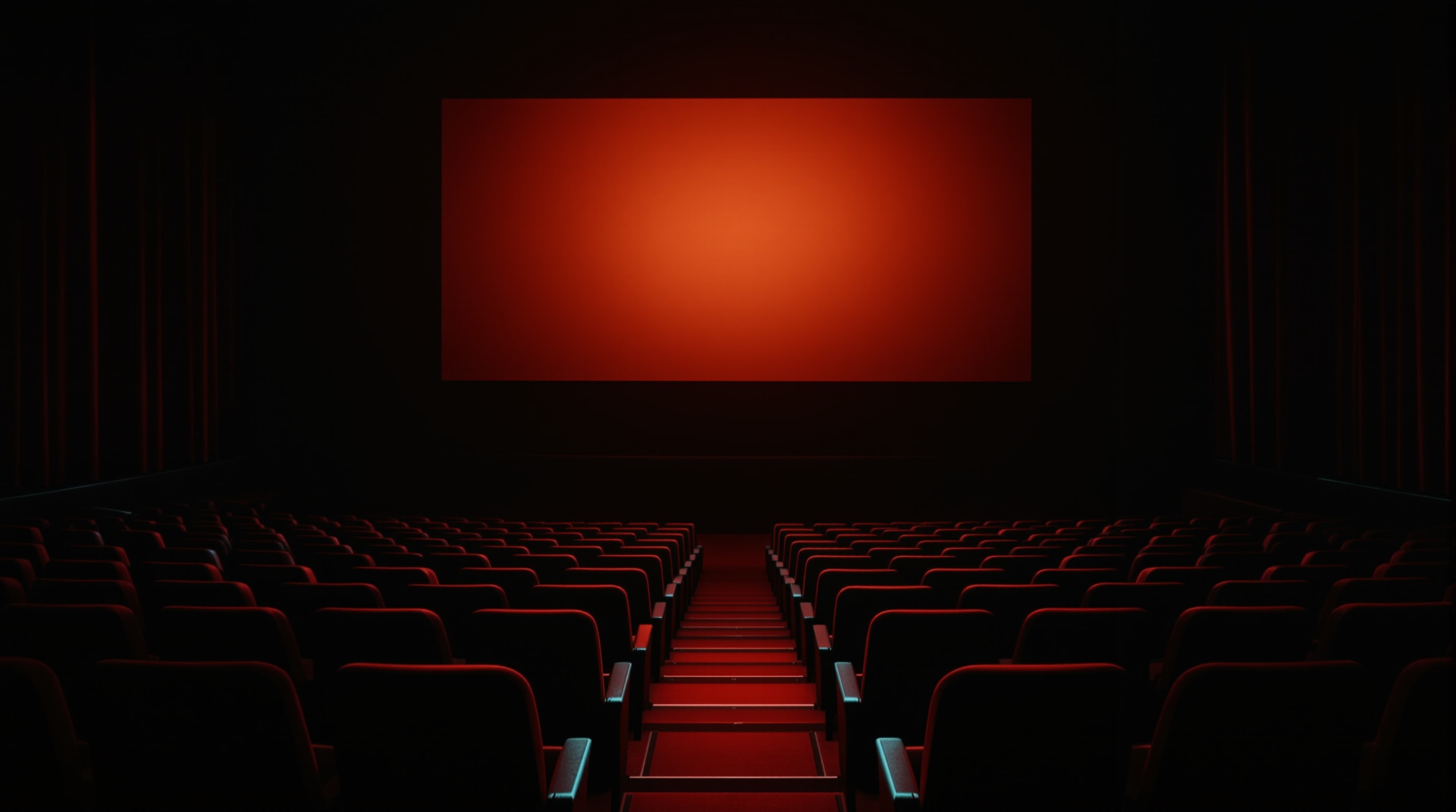 Empty cinema seats beneath a glowing blank screen
